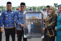 Penyerahan karikatur Bupati dan Ibu Bupati Kotabaru dalam peringatan Hari Pendidikan Nasional 2 Mei 2025.