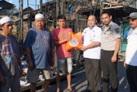 Staf Ahli Bupati Kotabaru, Zainal Arifin, S.Stp., M.Si., menyerahkan bantuan secara simbolis kepada warga terdampak kebakaran di Higa Gunung.