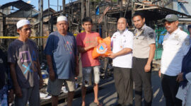 Staf Ahli Bupati Kotabaru, Zainal Arifin, S.Stp., M.Si., menyerahkan bantuan secara simbolis kepada warga terdampak kebakaran di Higa Gunung. 