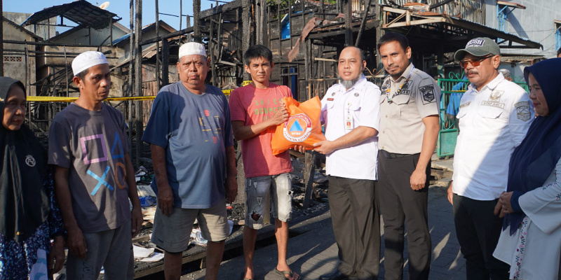Staf Ahli Bupati Kotabaru, Zainal Arifin, S.Stp., M.Si., menyerahkan bantuan secara simbolis kepada warga terdampak kebakaran di Higa Gunung. 