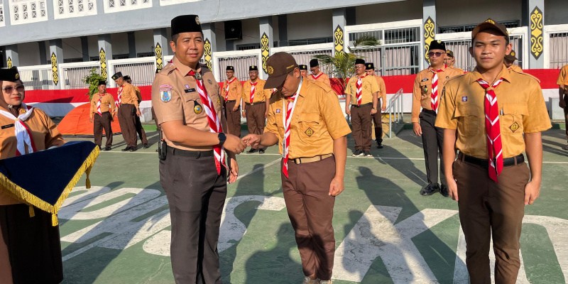 Kalapas Kotabaru Doni Handriansyah menyematkan tanda peserta kepada Warga Binaan dalam upacara pembukaan Perkemahan Satya Darma Bhakti Pemasyarakatan 2025 di Lapas Kelas IIA Kotabaru, Jumat (25/7)