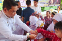 Sekretaris Daerah Kotabaru, Eka Saprudin, saat memberikan obat pencegahan cacingan kepada siswa SDN Dirgahayu dalam program POPM tahap II.