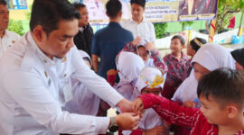 Sekretaris Daerah Kotabaru, Eka Saprudin, saat memberikan obat pencegahan cacingan kepada siswa SDN Dirgahayu dalam program POPM tahap II.