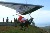 Aksi memukau atlet gantole saat lepas landas dari bukit, bagian dari Paragliding Accuracy Championship Kotabaru Hebat 2025.