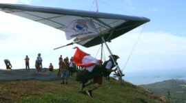 Aksi memukau atlet gantole saat lepas landas dari bukit, bagian dari Paragliding Accuracy Championship Kotabaru Hebat 2025.