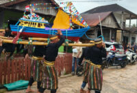 Warga Teluk Tamiang mengangkat kapal hias untuk prosesi pelepasan ke laut pada tradisi Mappanre Tasi 2025.
