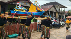 Warga Teluk Tamiang mengangkat kapal hias untuk prosesi pelepasan ke laut pada tradisi Mappanre Tasi 2025.