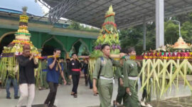 Warga bergotong-royong mengangkat tumpeng raksasa, menandai dimulainya ritual budaya Grebek Kampung di Desa Sebelimbingan. (Foto:Ummy/klikindonesia) 