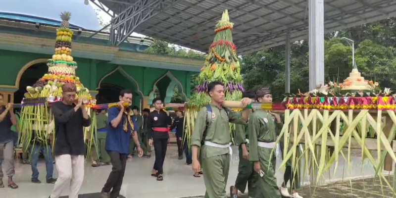 Warga bergotong-royong mengangkat tumpeng raksasa, menandai dimulainya ritual budaya Grebek Kampung di Desa Sebelimbingan. (Foto:Ummy/klikindonesia) 